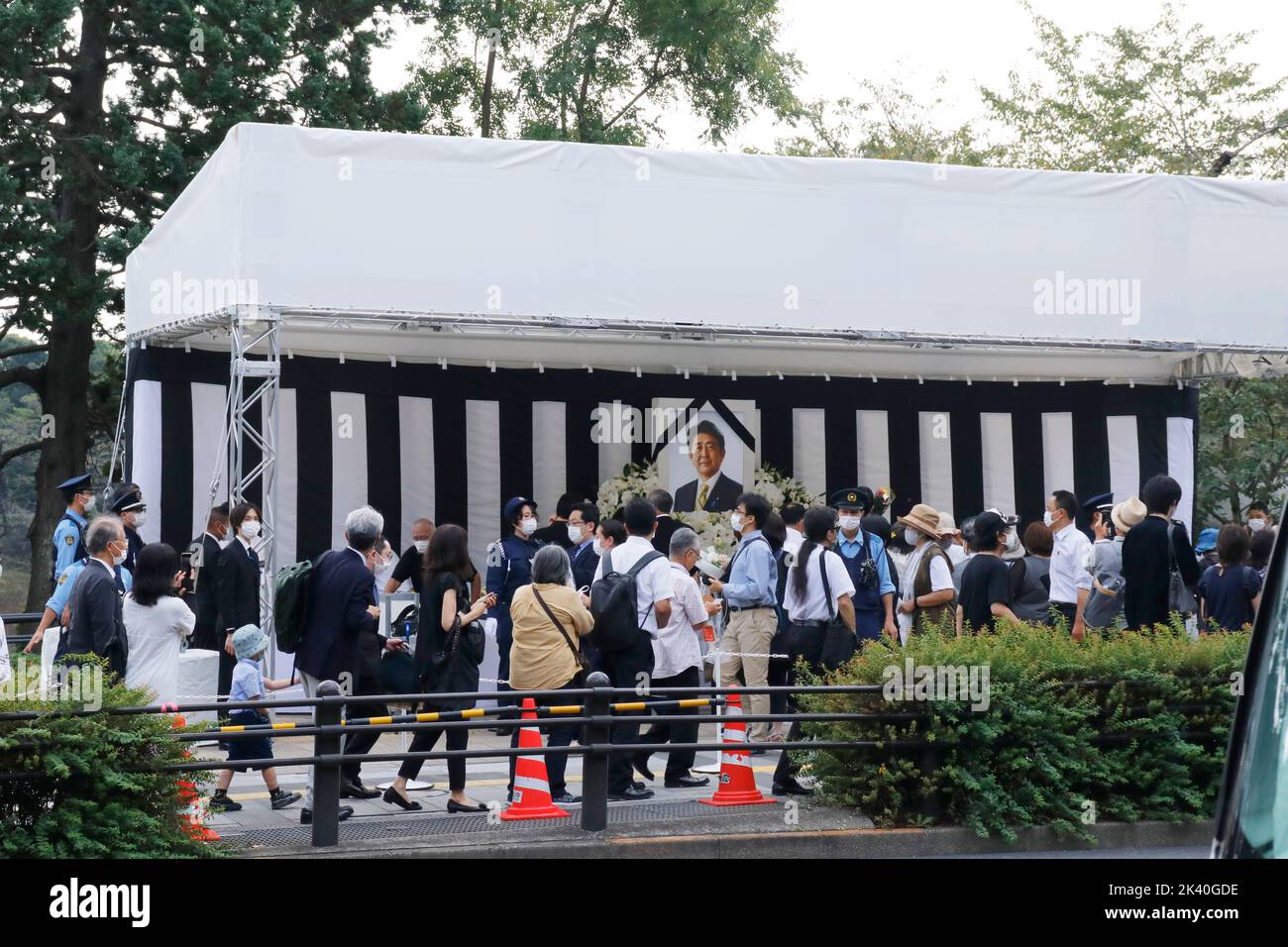 La gente attende in fila per pregare e offrire fiori presso la fioriera allestita specialmente fuori da Nippon Budokan, dove il funerale di stato per l'ex primo ministro giapponese Shinzo Abe si tiene il 27 settembre 2022 a Tokyo, Giappone. Foto Stock