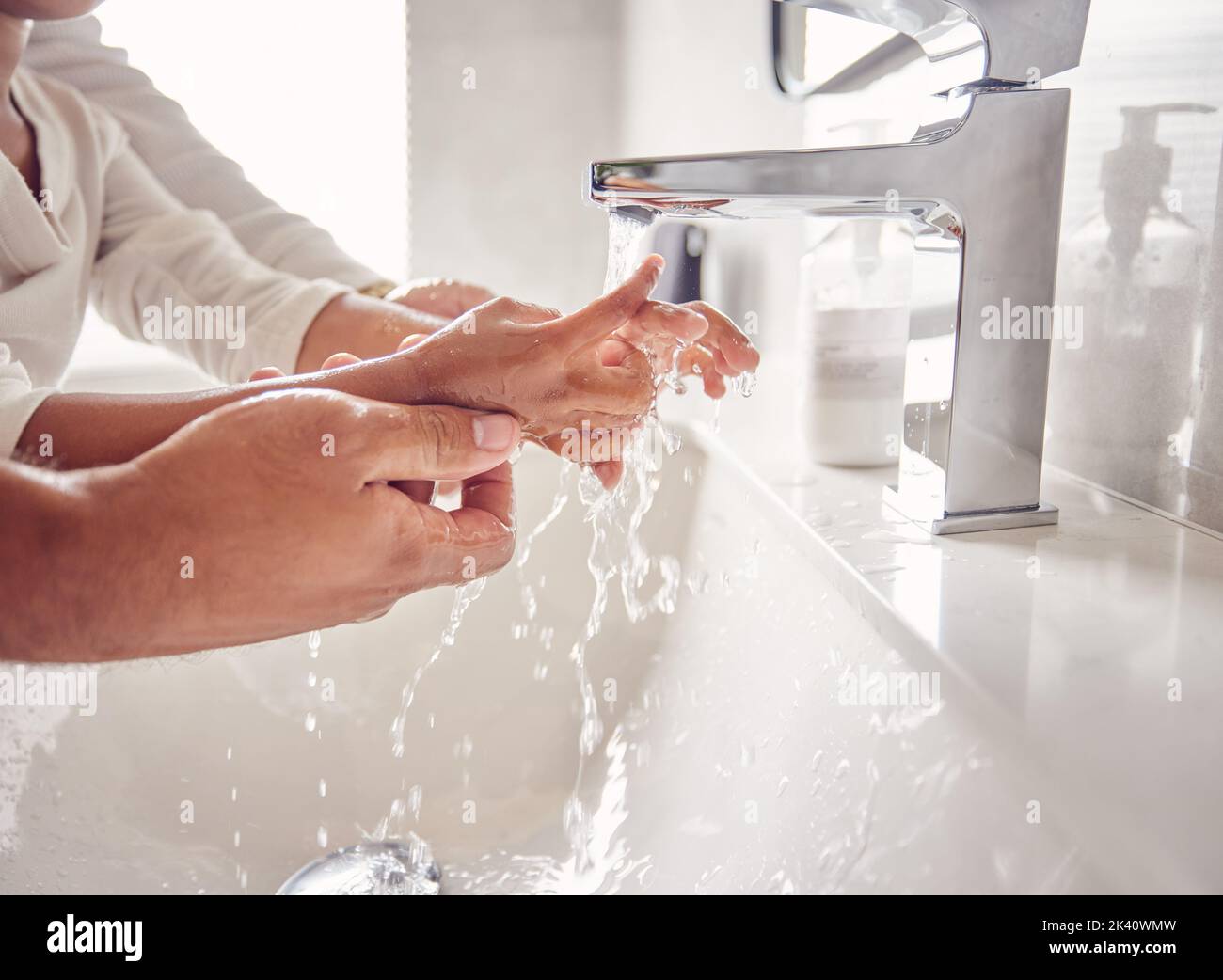 Pulizia, mani e acqua con una ragazza e un uomo nel bagno della loro casa insieme. Bambini, bambini e igiene con il lavaggio di un padre e di una figlia Foto Stock