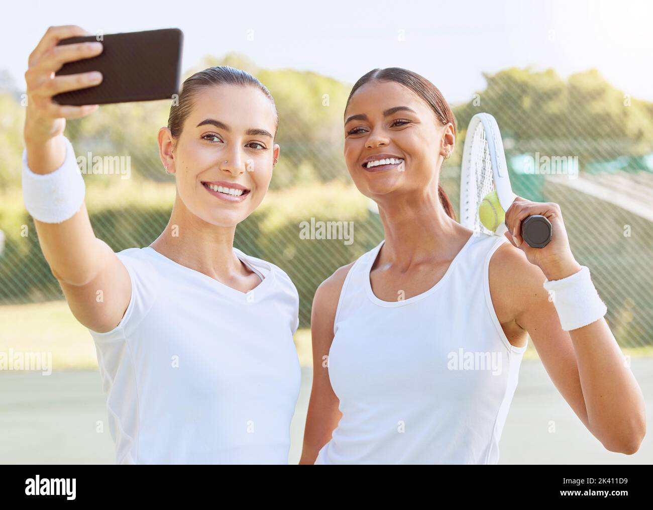 Selfie tennis, videochiamata telefonica e donne allenarsi in campo insieme, felice con il gioco sportivo e parlare su smartphone. Squadra atleta che scatta foto Foto Stock