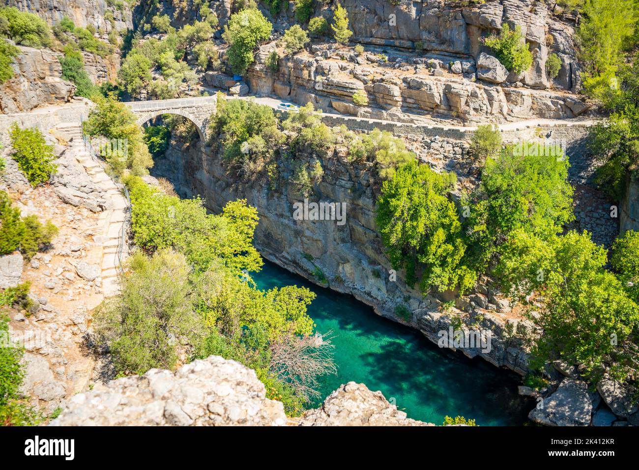 Antico ponte ad arco sulla gola del fiume Koprucay nel Parco Nazionale di Koprulu in Turchia. Vista panoramica del canyon e della montagna dalle tempeste blu Foto Stock