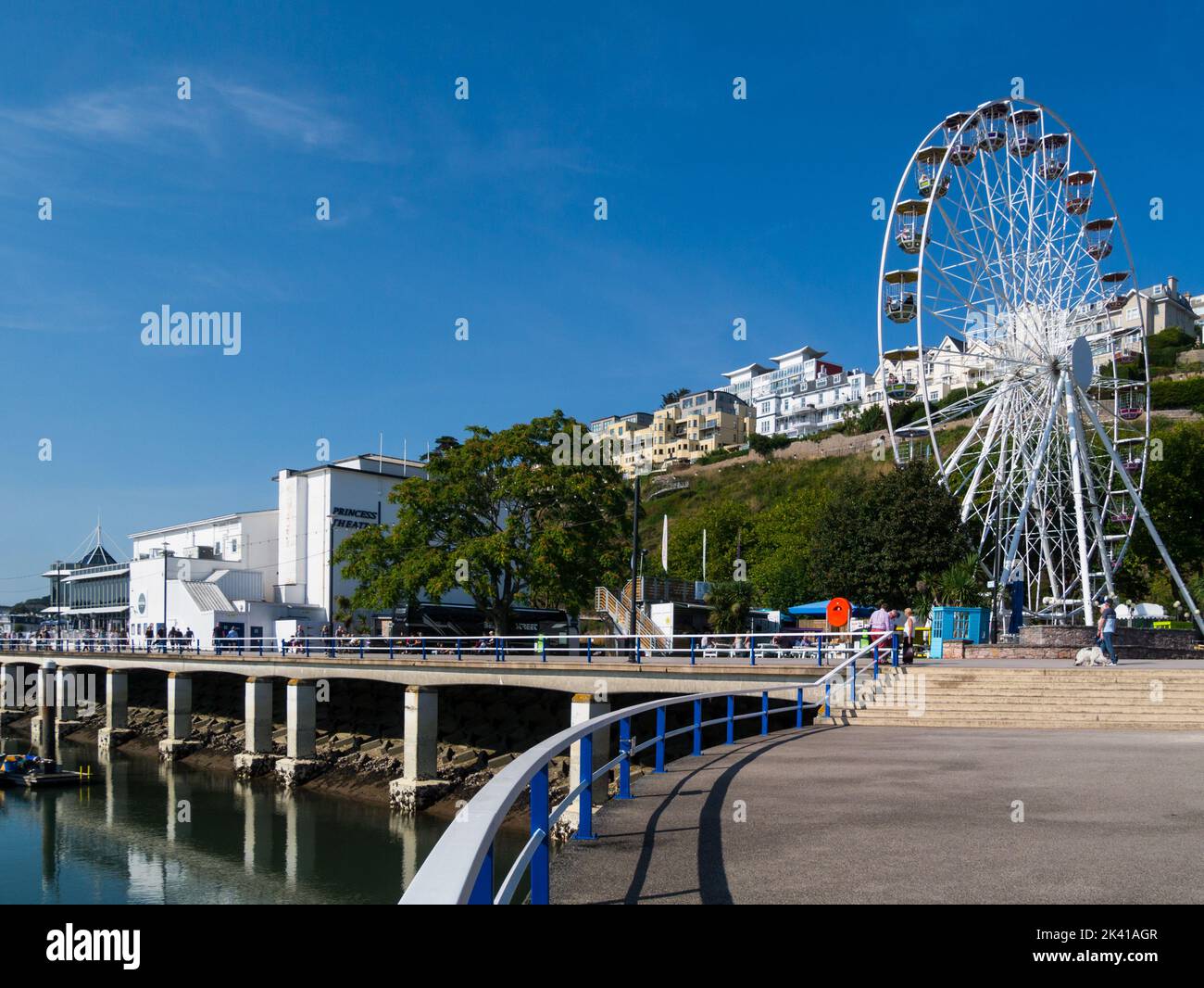 Guardando lungo il lungomare di Torquay verso la English Riviera Wheel e il Princess Theatre in una bella giornata di settembre con il cielo blu chiaro Devon Inghilterra UK Foto Stock