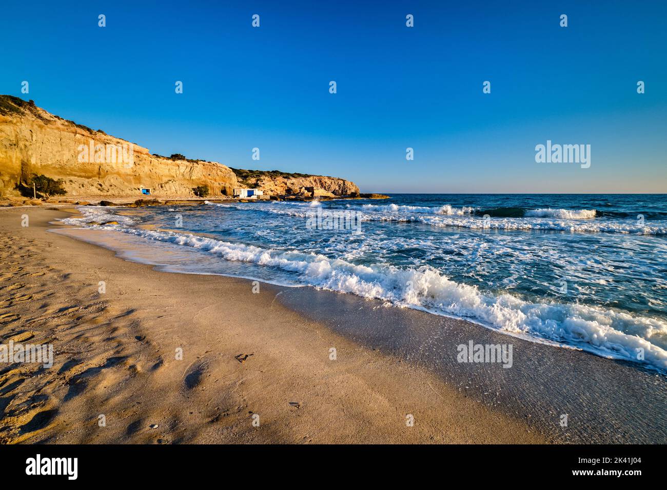 Splendida vista al tramonto della spiaggia di Fyriplaka, isola di Milos, Grecia. Vacanze greche, Mar Egeo, paesaggio roccioso, acque azzurre, spiaggia sabbiosa. Foto Stock