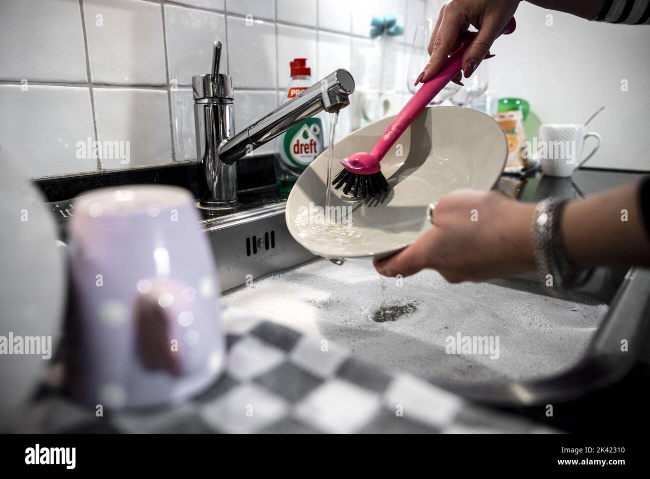 2022-09-29 14:02:27:19 ILLUSTRATIVO - Una donna è lavare piatti a mano per risparmiare energia. Le forniture di gas dalla Russia sono in calo a seguito della guerra con l’Ucraina. ANP ROB ENGELAAR olanda fuori - belgio fuori Foto Stock