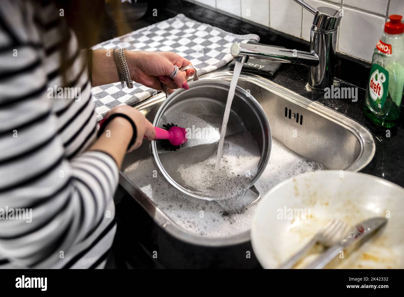 2022-09-29 13:58:44:19 ILLUSTRATIVO - Una donna è lavare piatti a mano per risparmiare energia. Le forniture di gas dalla Russia sono in calo a seguito della guerra con l’Ucraina. ANP ROB ENGELAAR olanda fuori - belgio fuori Foto Stock