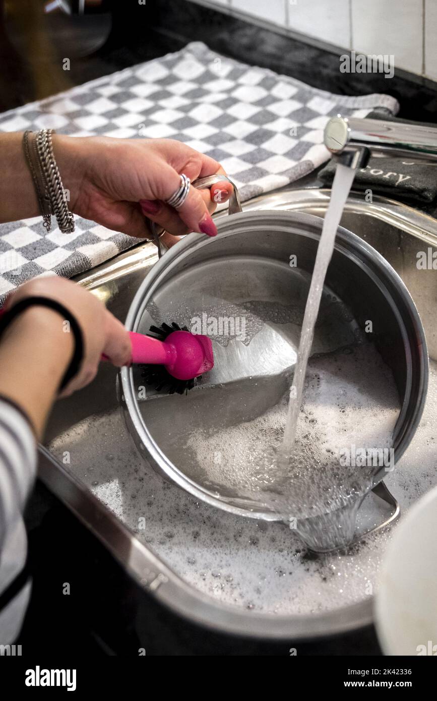 2022-09-29 13:58:44:19 ILLUSTRATIVO - Una donna è lavare piatti a mano per risparmiare energia. Le forniture di gas dalla Russia sono in calo a seguito della guerra con l’Ucraina. ANP ROB ENGELAAR olanda fuori - belgio fuori Foto Stock