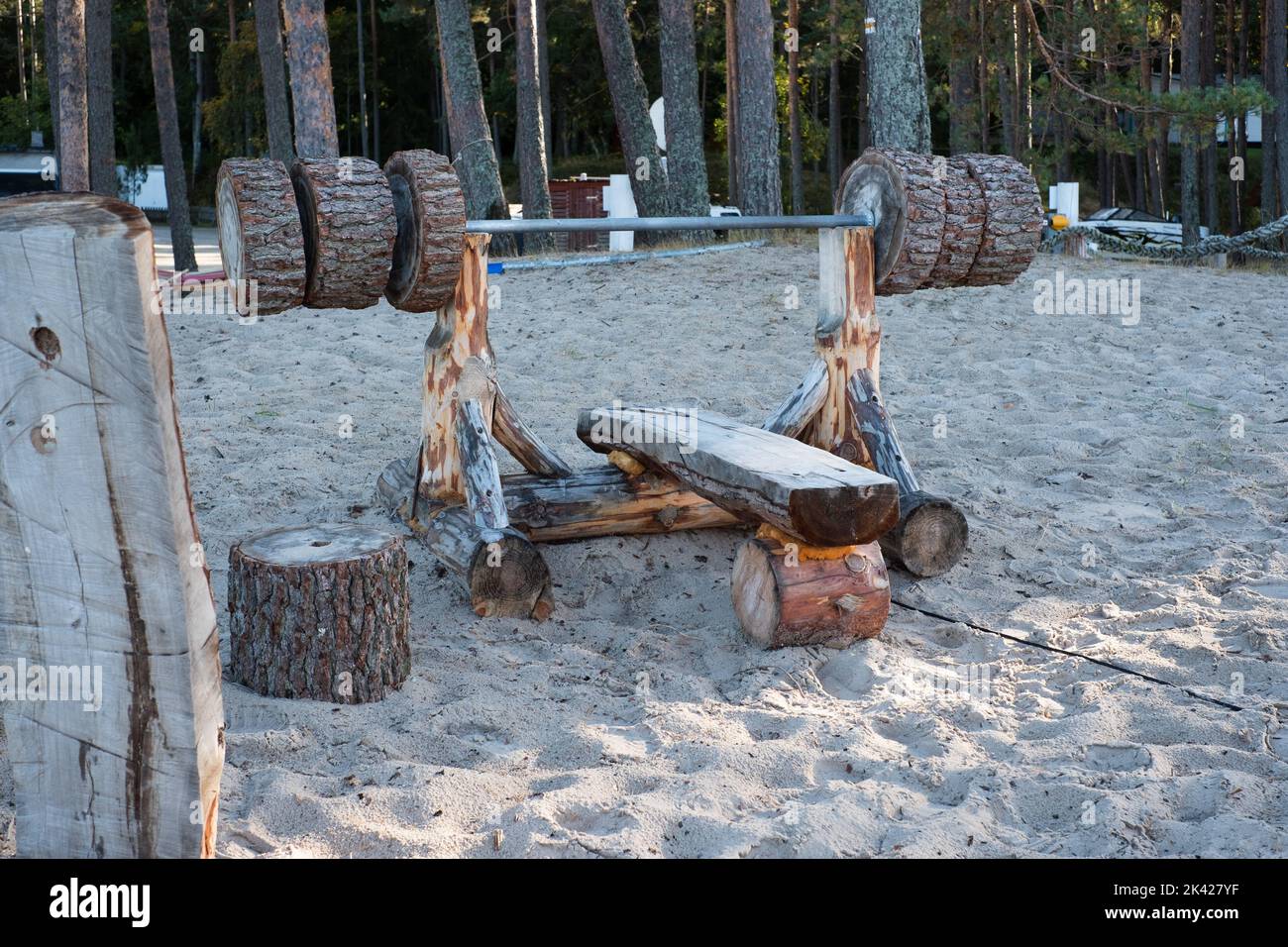 Pressa per panchine in legno in un parco fatto di tronchi pesanti. Foto Stock