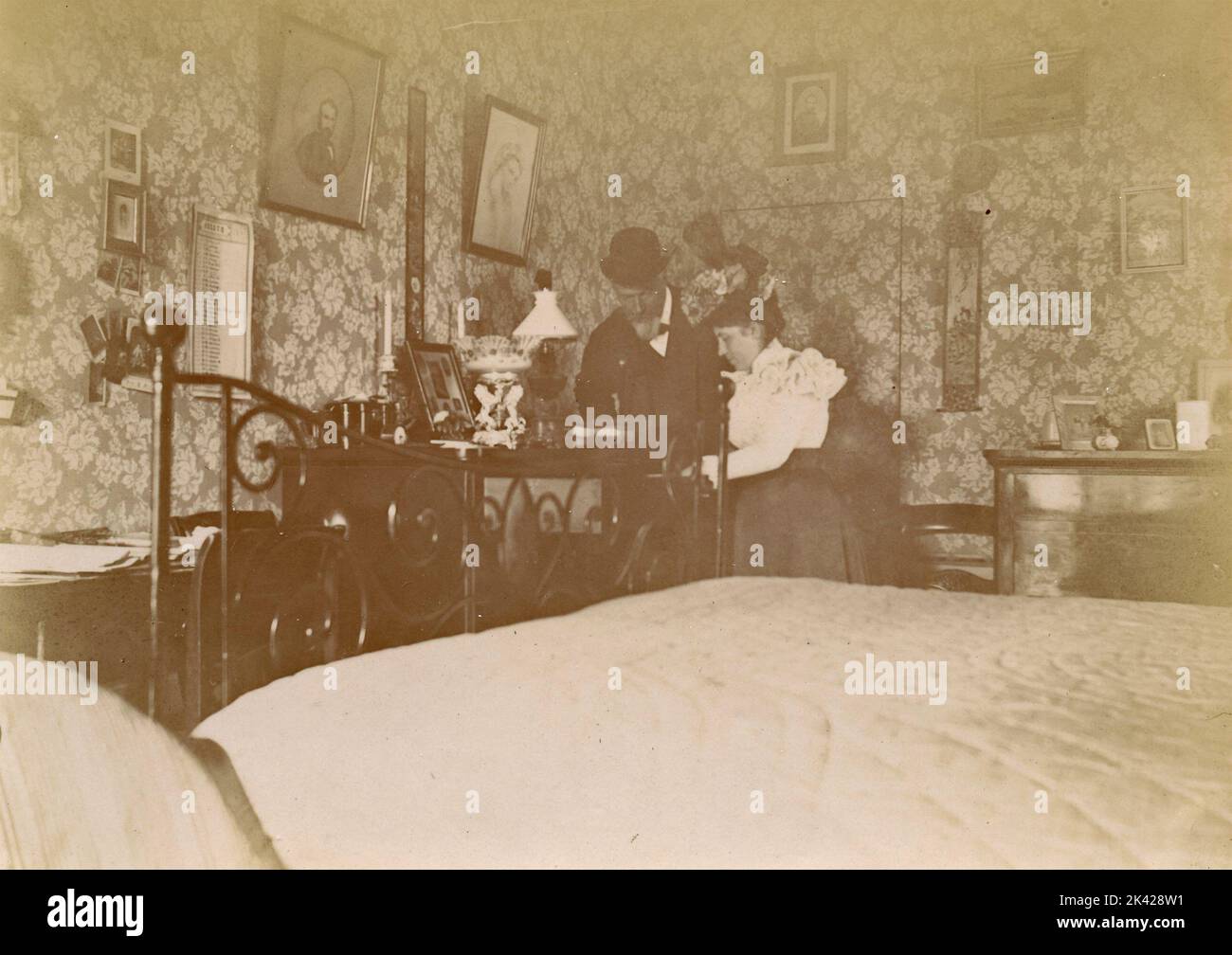 Una coppia in camera alla ricerca di qualcosa, Italia 1890s Foto Stock