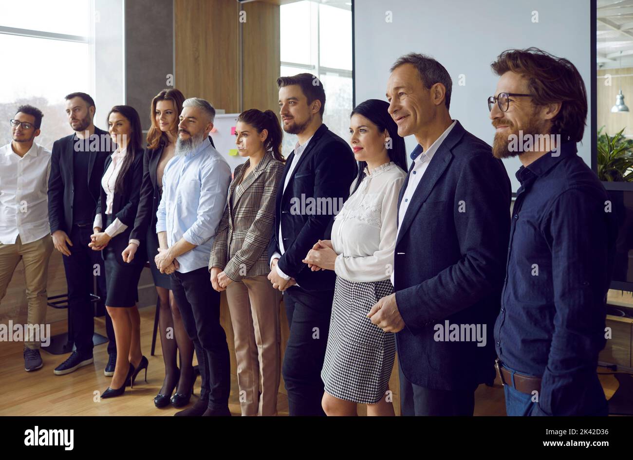 Uomini e donne di diverse età in fila nella sala conferenze Foto Stock