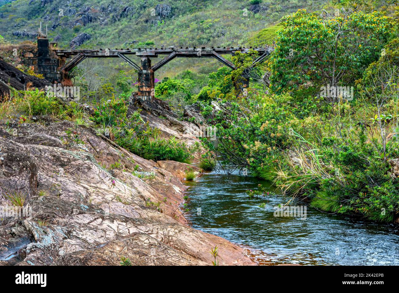 Torrente attraverso la vegetazione della riserva Biribiri a Diamantina con un vecchio ponte in legno costruito da schiavi per drenare la produzione di diamanti e. Foto Stock