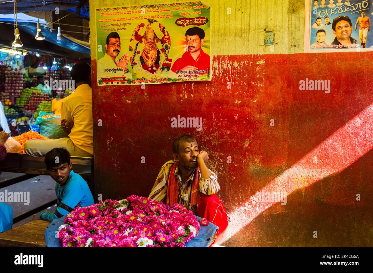 Mysore, Karnataka, India : Un uomo siede in una bancarella di fiori al mercato di Devaraja. Foto Stock