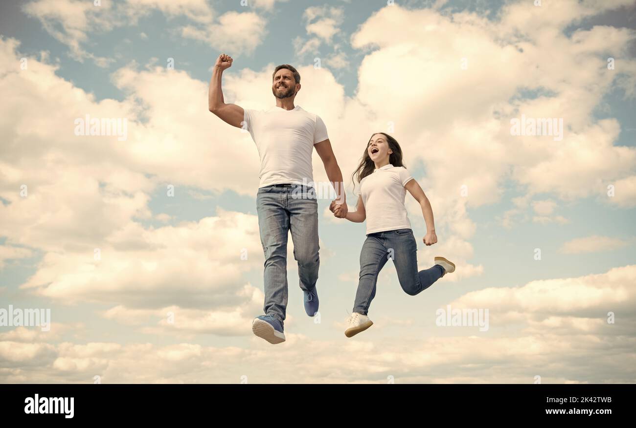 felice padre e figlia saltano nel cielo. felice infanzia Foto Stock