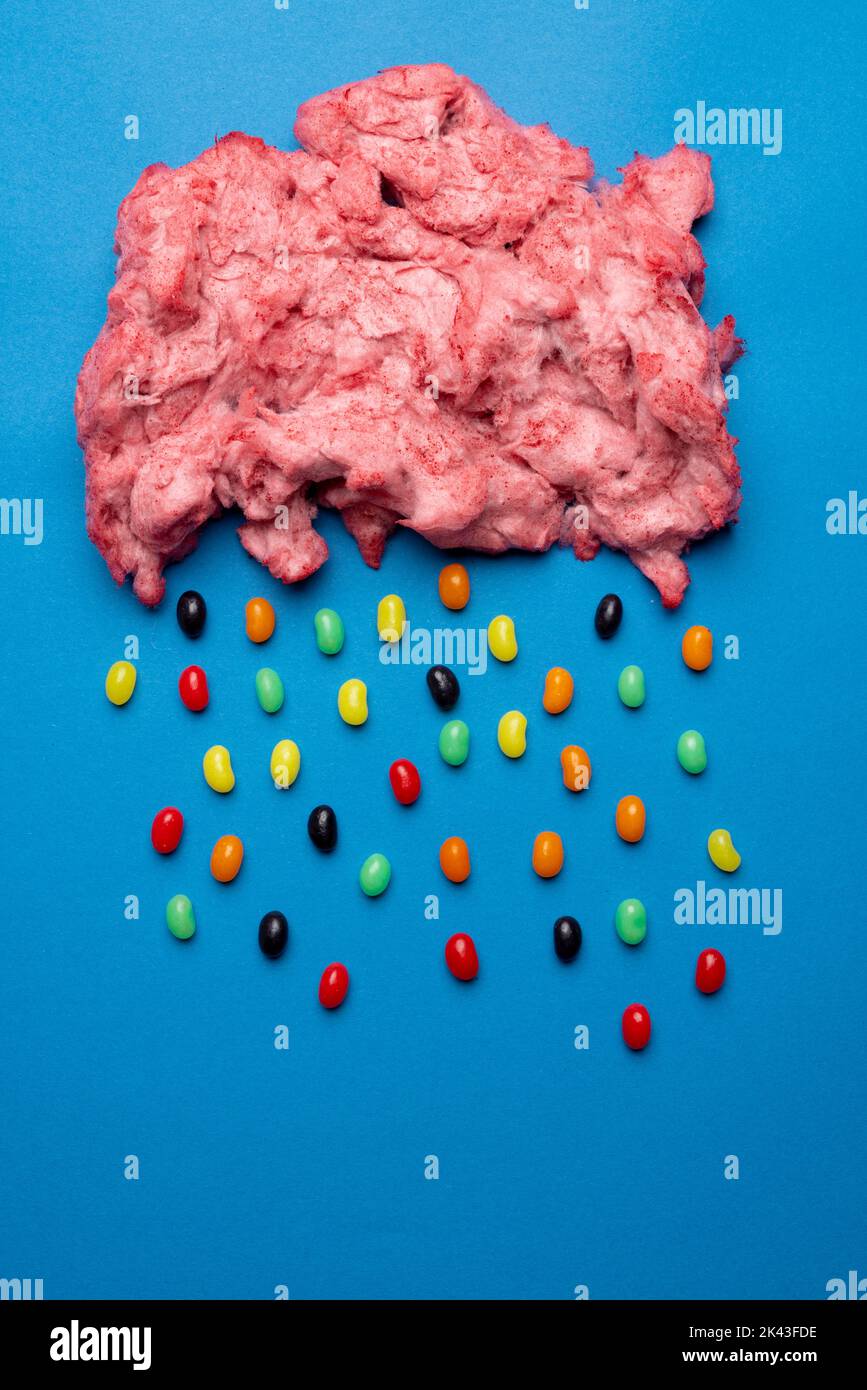 Immagine verticale di nuvola di caramelle fatte in casa rosa floss pioggia di jelly beans, su blu con spazio copia Foto Stock