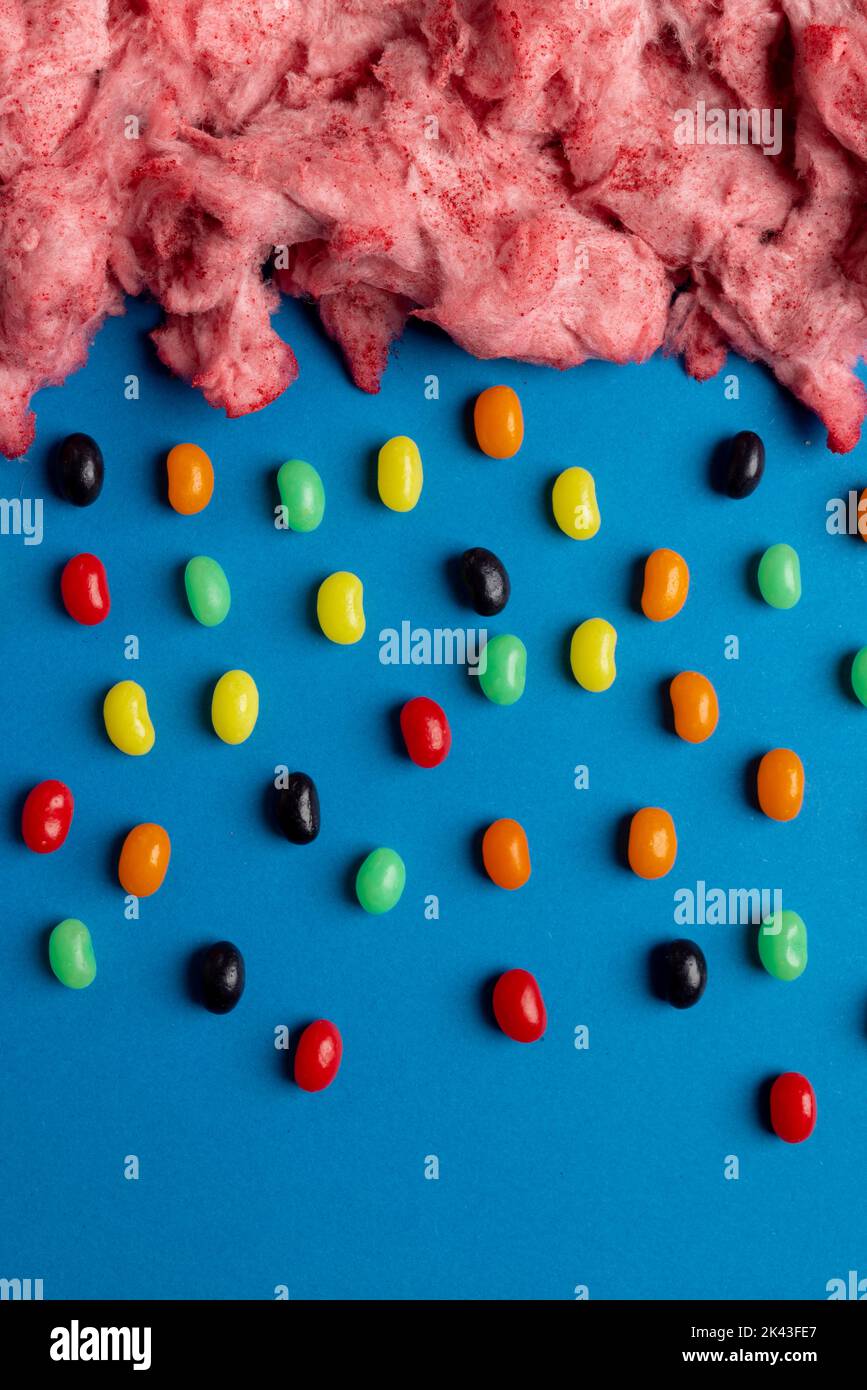 Immagine verticale di nuvola di caramelle fatte in casa rosa floss pioggia di jelly beans, su blu con spazio copia Foto Stock