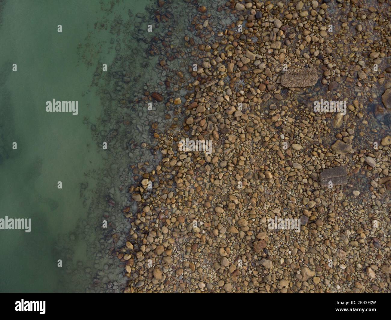 Vista sul mare verde e sulla riva del mare con ciottoli Foto Stock