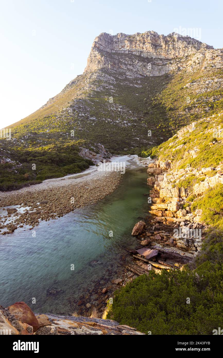 Paesaggio di mare con rocce, montagne, cielo azzurro e orizzonte Foto Stock