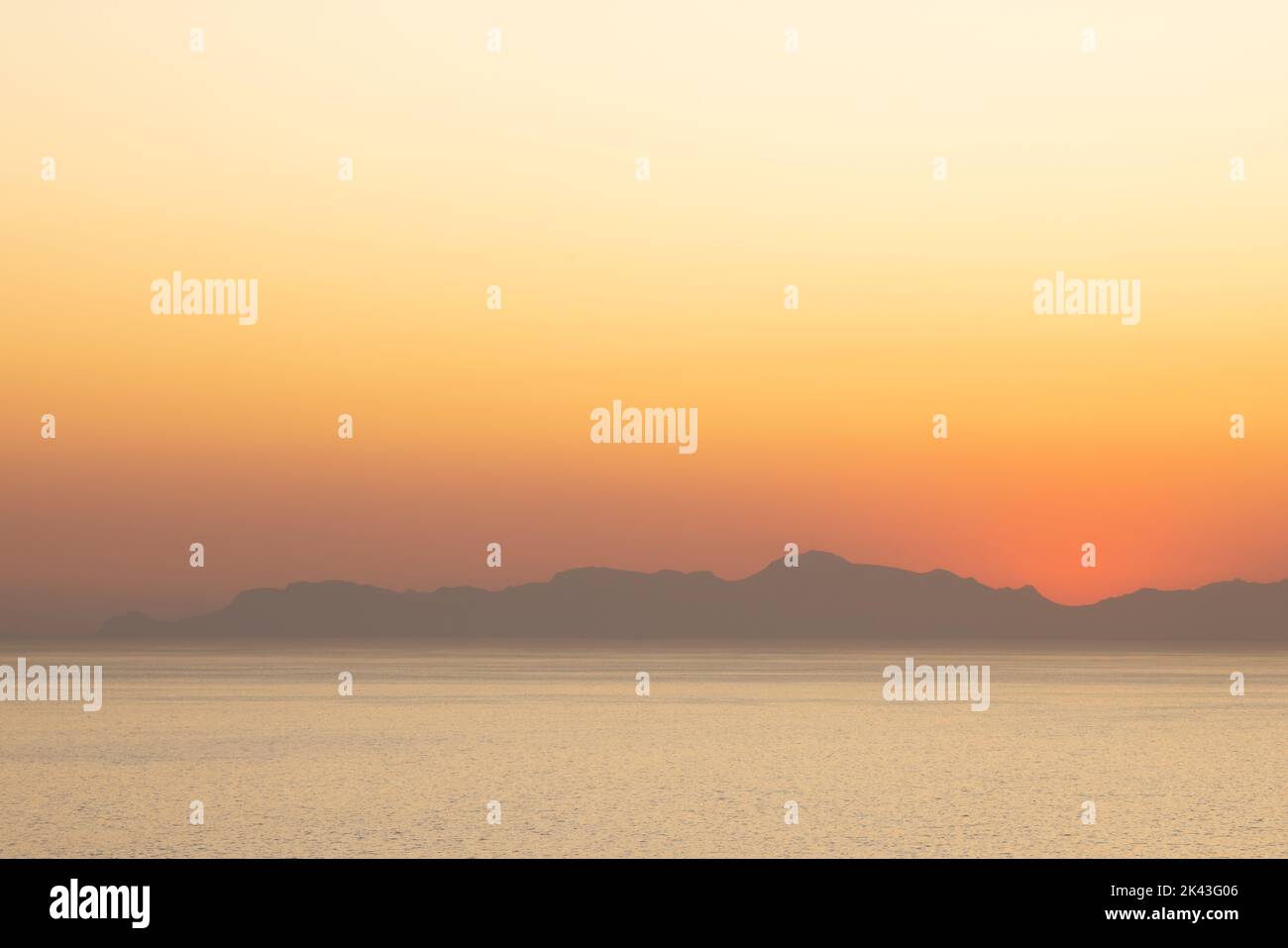 Paesaggio di mare, riva del mare con montagne, cielo senza nuvole al tramonto e all'orizzonte Foto Stock