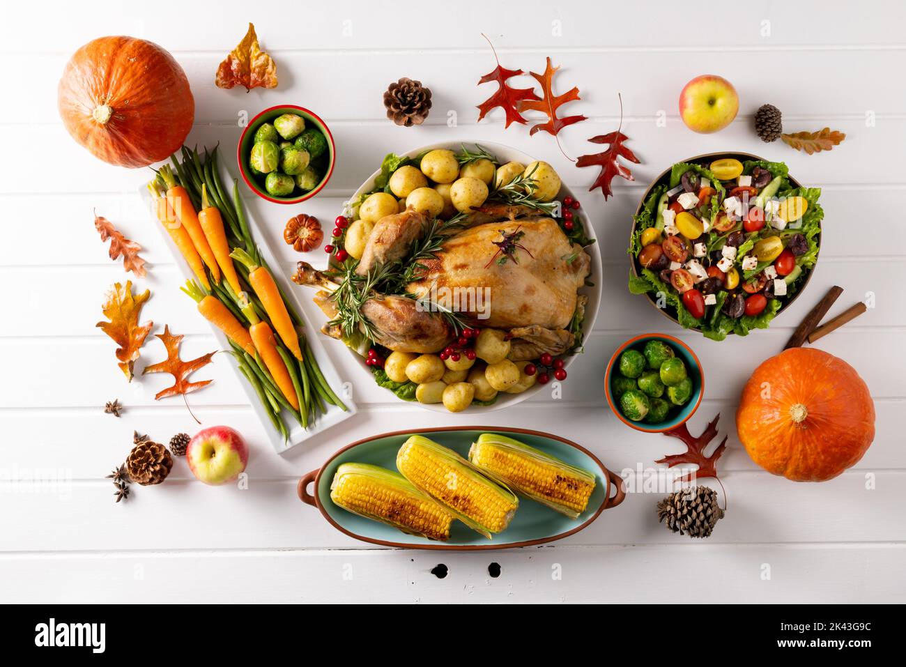 Vista dall'alto del tavolo del ringraziamento con tacchino arrosto, verdure e decorazione autunnale su legno Foto Stock