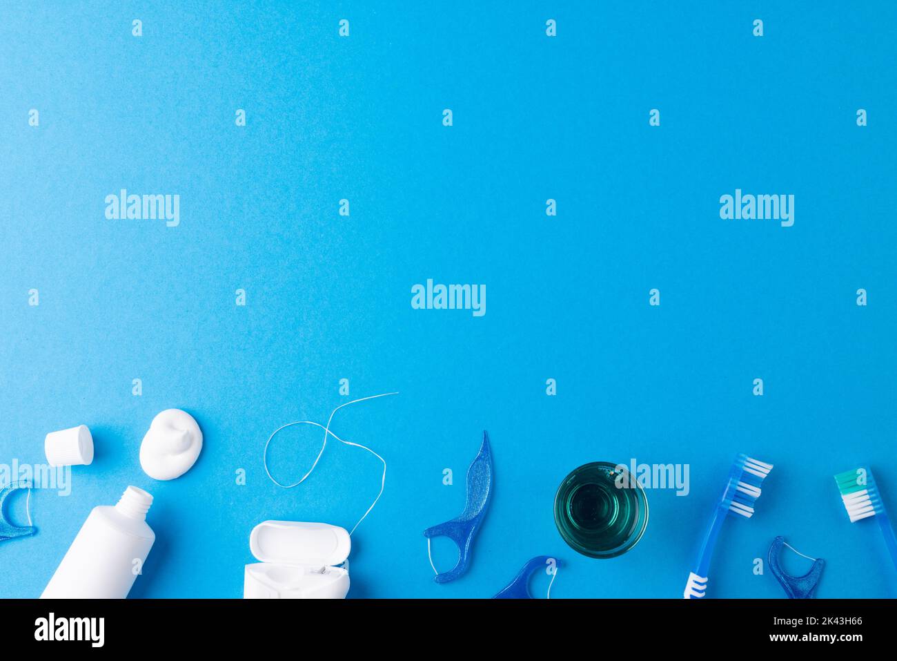 Immagine di spazzolino da denti, dentifricio, filo e liquido sulla superficie blu Foto Stock