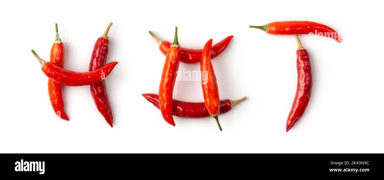 Parola 'CALDO' fatta di peperoncini rossi isolati su fondo bianco, motivo fatto di verdure comuni mature usate per il loro gusto speziato, giacitura piatta Foto Stock