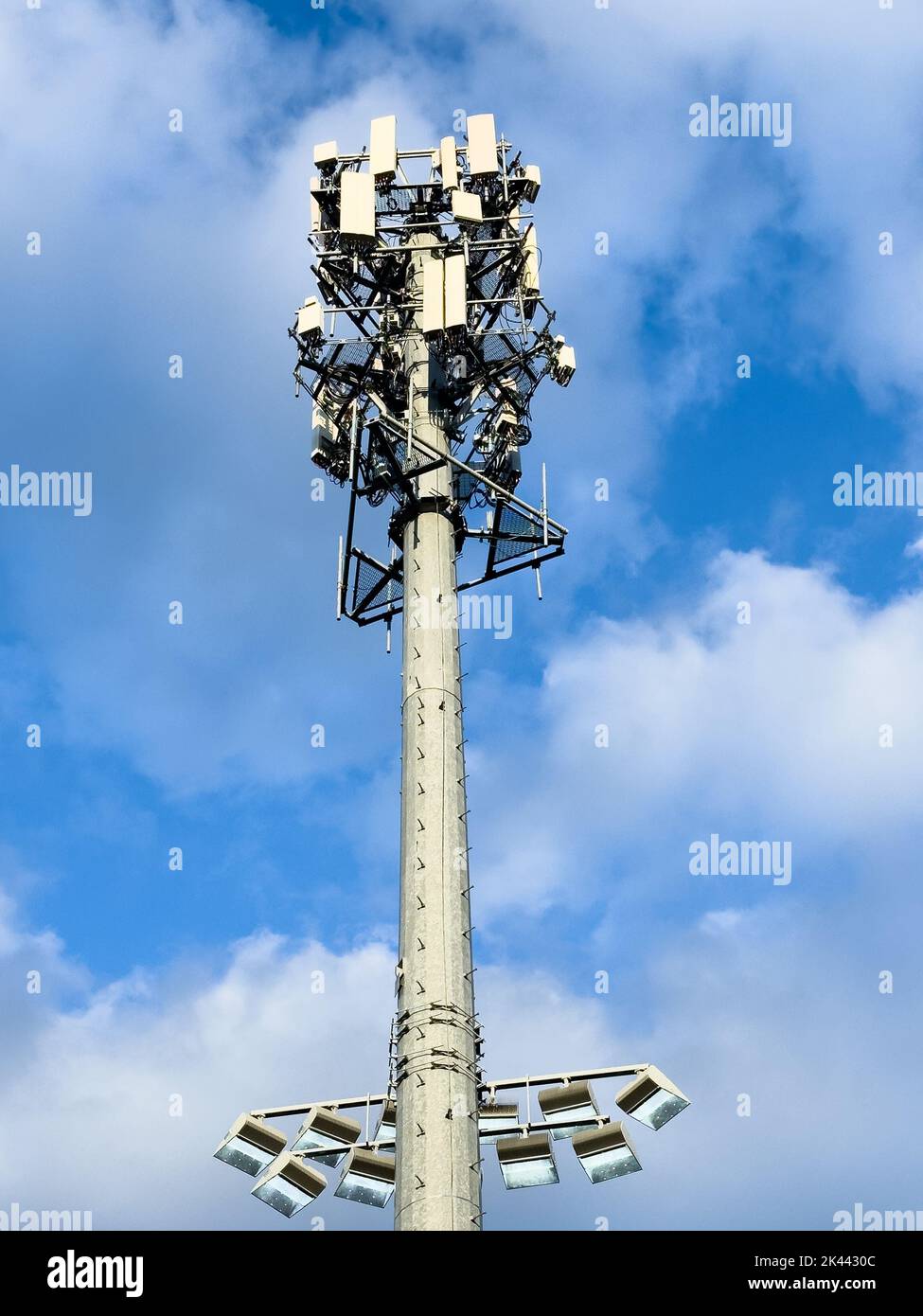 Torre di telecomunicazione con antenne contro il cielo nuvoloso blu Foto Stock