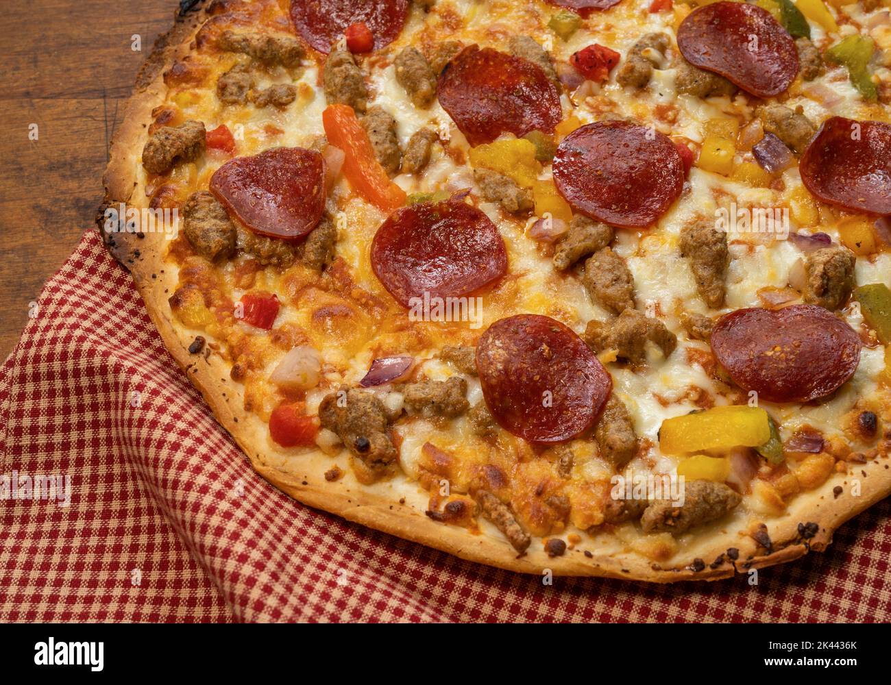 Pizza su tavolo di legno con panno rosso Foto Stock