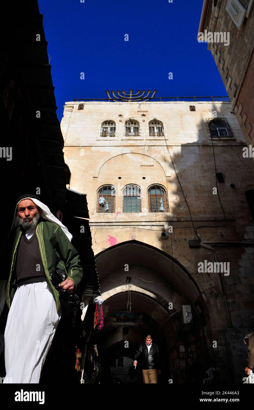 Un uomo palestinese che cammina nel quartiere musulmano della città vecchia di Gerusalemme. Foto Stock