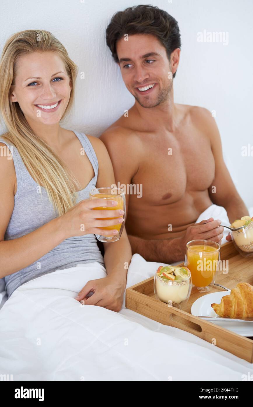 Ama i sabati lenti. Una giovane coppia felice che ha fatto colazione a letto. Foto Stock