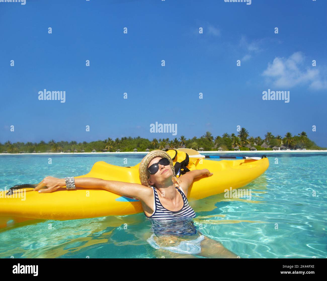 Completa beatitudine. Una bella giovane donna che si rilassa in un oceano tropicale con la sua barca. Foto Stock