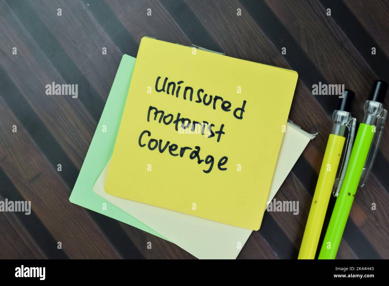 Concetto di automobilista non assicurato copertura scrivere su foglietti adesivi isolati su tavola di legno. Foto Stock