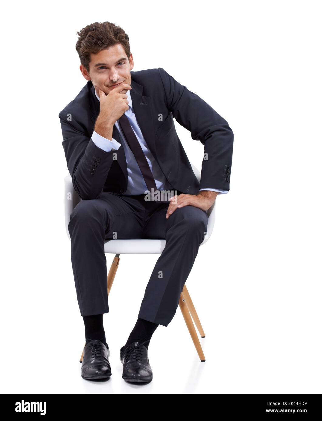 Domandandosi chi assumere. Un giovane uomo d'affari pensivo seduto sulla sua sedia. Foto Stock