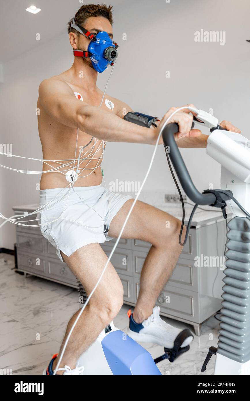 Uomo che esamina il suo sistema cardiovascolare su simulatore di bici Foto Stock