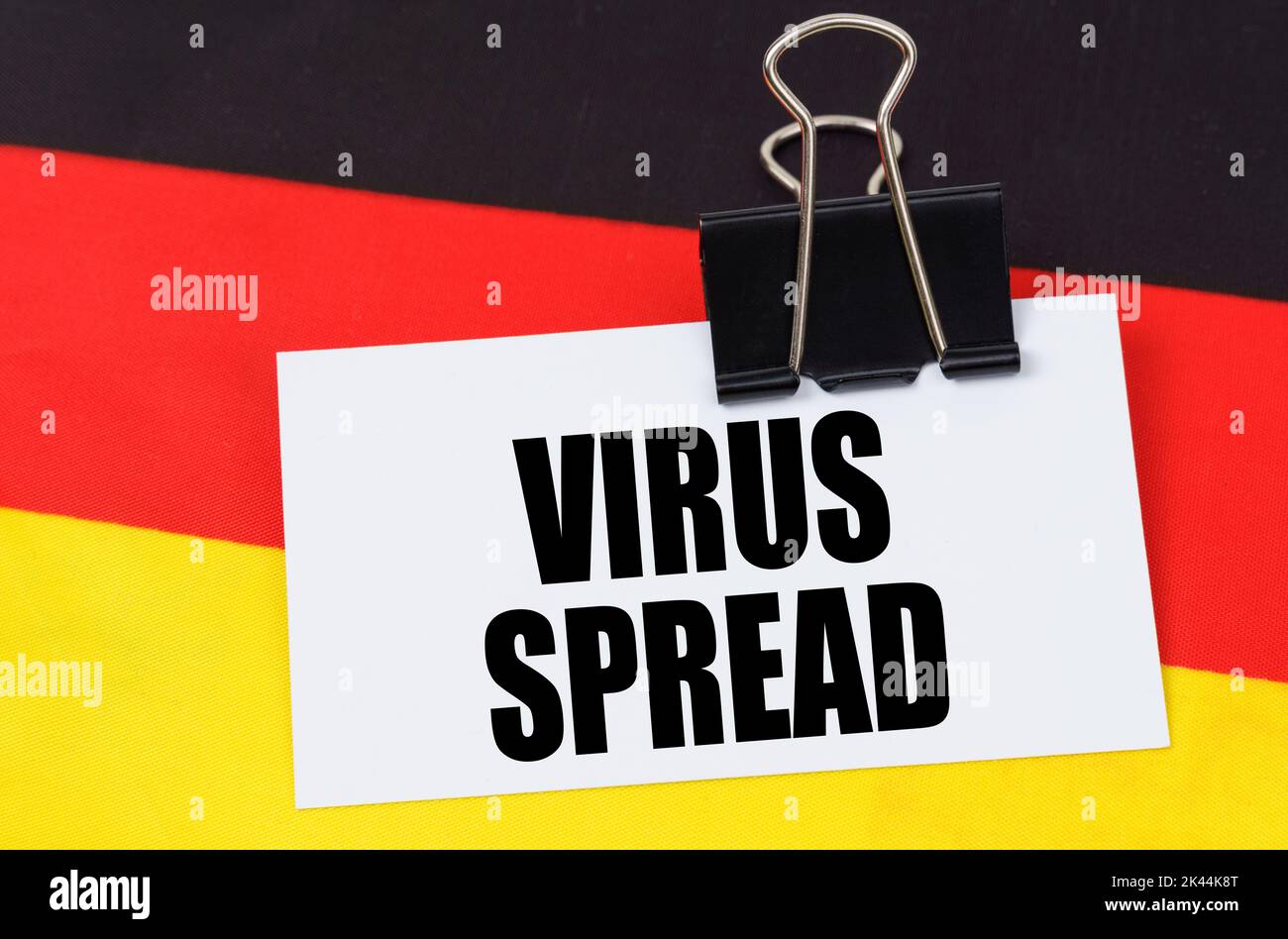 Concetto di medicina nazionale. Sulla bandiera della Germania si trova un taccuino con l'iscrizione - DIFFUSIONE DEL VIRUS Foto Stock