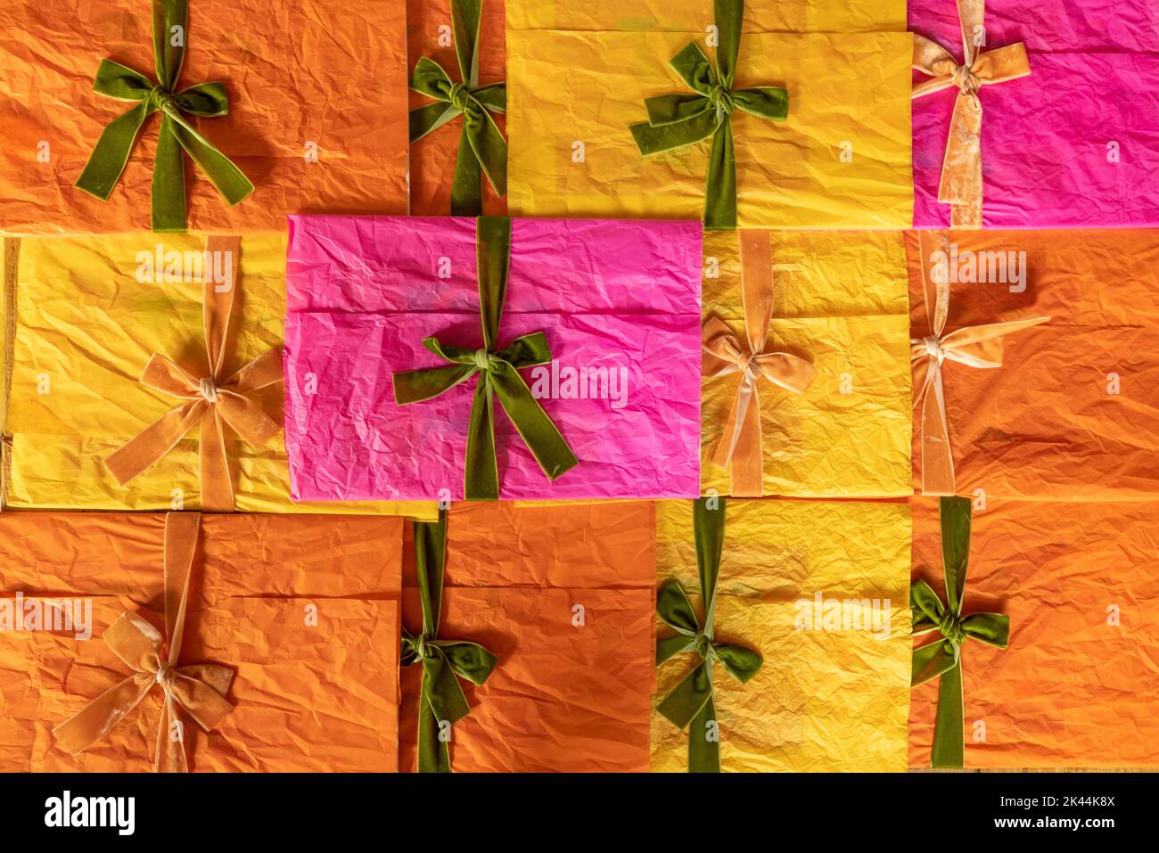 Buste multicolore decorate con nastri e archi impilati insieme Foto Stock