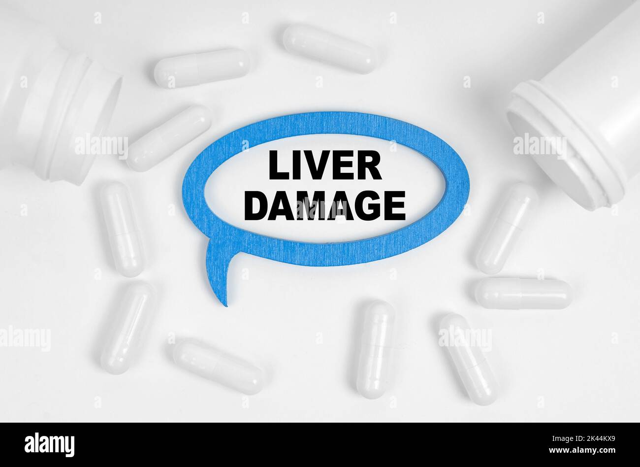 Concetto di medicina. Sul tavolo ci sono pillole e una placca blu all'interno della quale l'iscrizione - danno epato Foto Stock