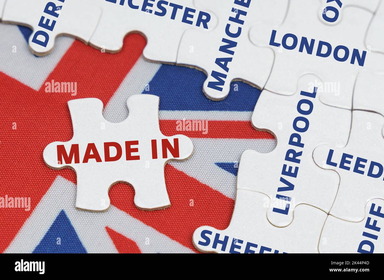 Concetto nazionale. Sulla bandiera della Gran Bretagna ci sono puzzle con i nomi delle città e un puzzle separato con l'iscrizione - Made in Foto Stock