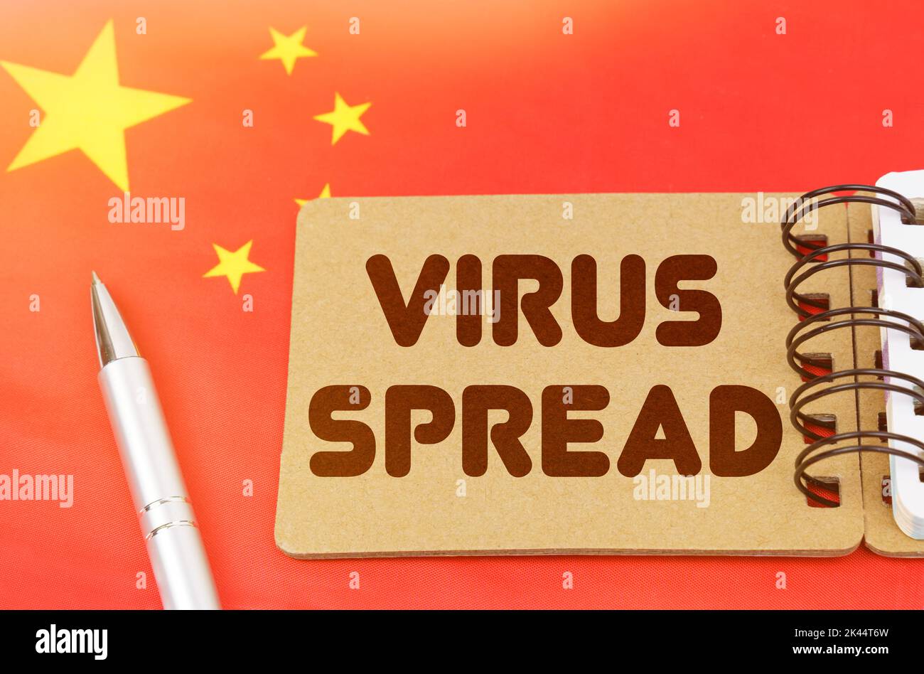 Concetto di medicina nazionale. Sulla bandiera della Cina si trova un taccuino con l'iscrizione - DIFFUSIONE DEL VIRUS Foto Stock