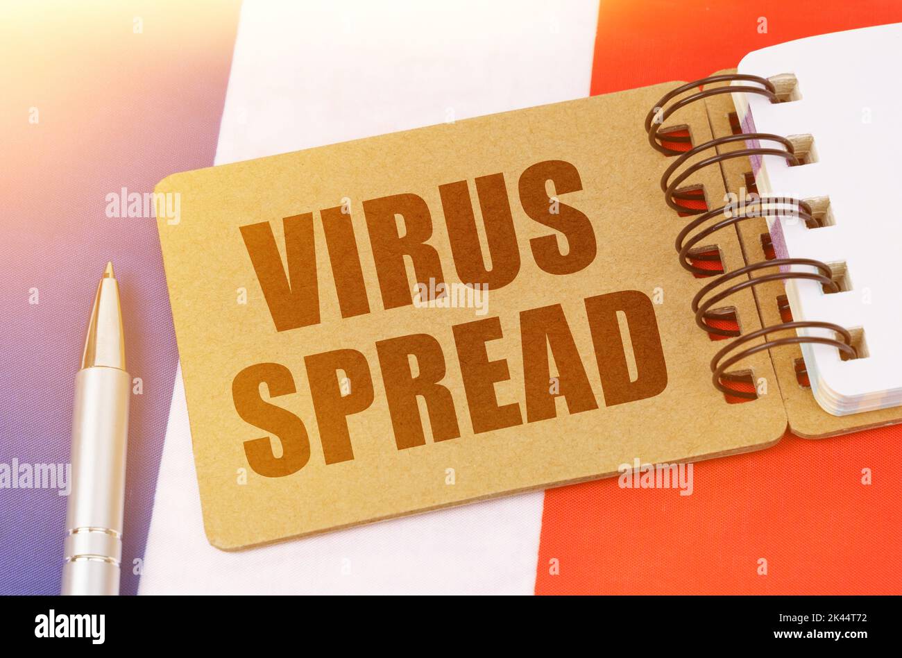 Concetto di medicina nazionale. Sulla bandiera della Francia si trova un taccuino con l'iscrizione - DIFFUSIONE DEL VIRUS Foto Stock