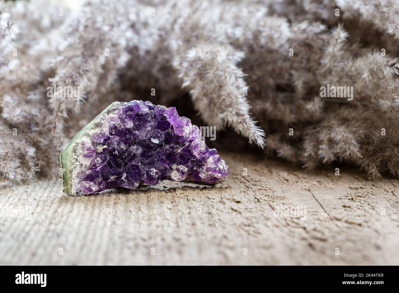 Cristallo ametista druzy una varietà viola di quarzo su sfondo di legno. Healing il concetto del cristallo, ametista è buono per alleviare l'ansia e lo sforzo. Na Foto Stock