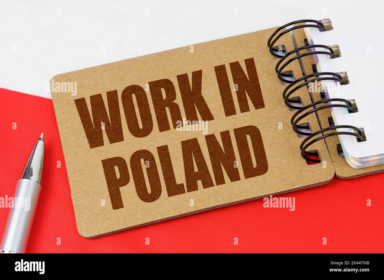 Concetto di economia nazionale. Sulla bandiera della Polonia si trova un quaderno con l'iscrizione - lavoro in Polonia Foto Stock