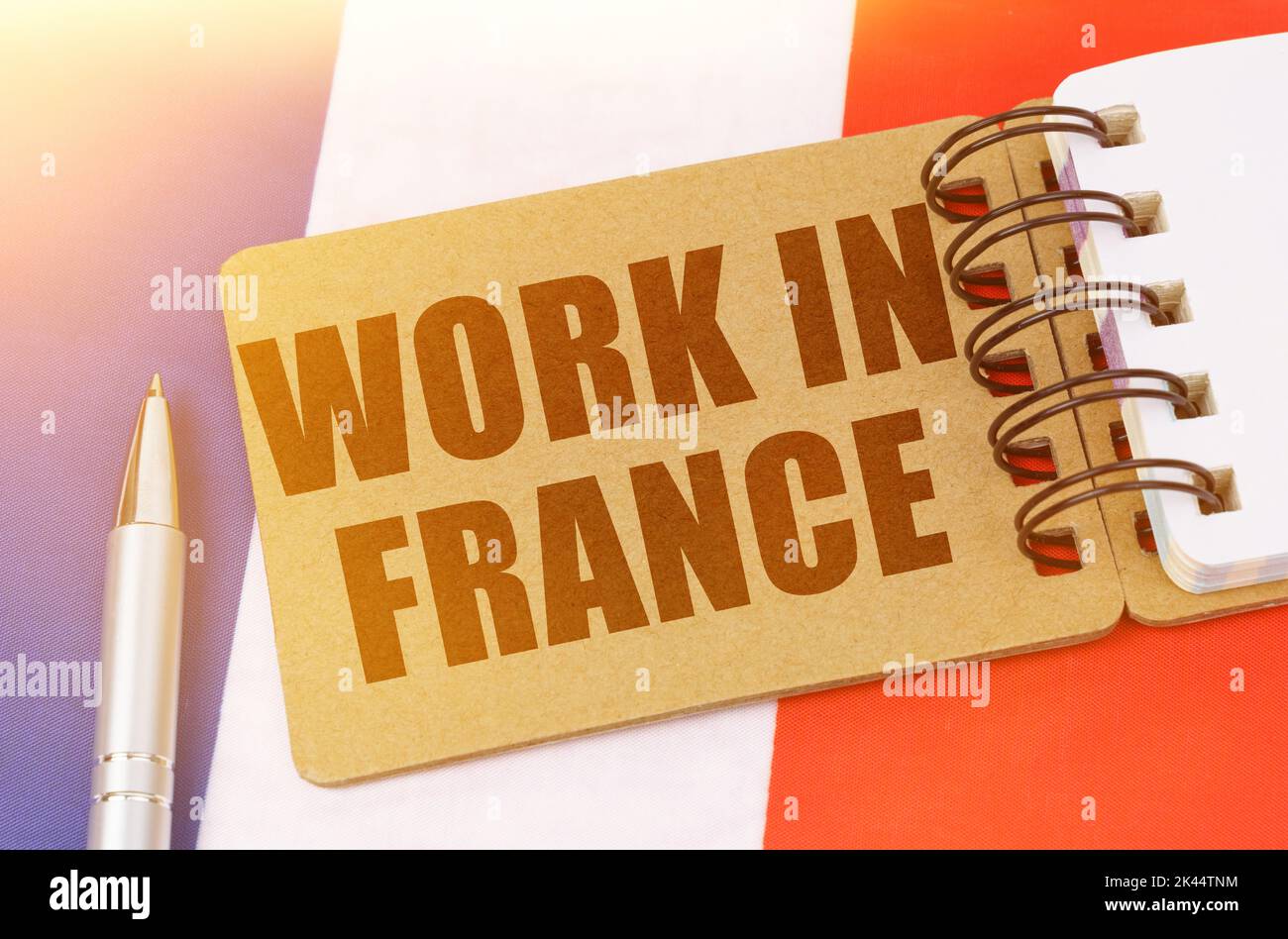 Concetto di economia nazionale. Sulla bandiera di Francia si trova un taccuino con l'iscrizione - lavoro in Francia Foto Stock