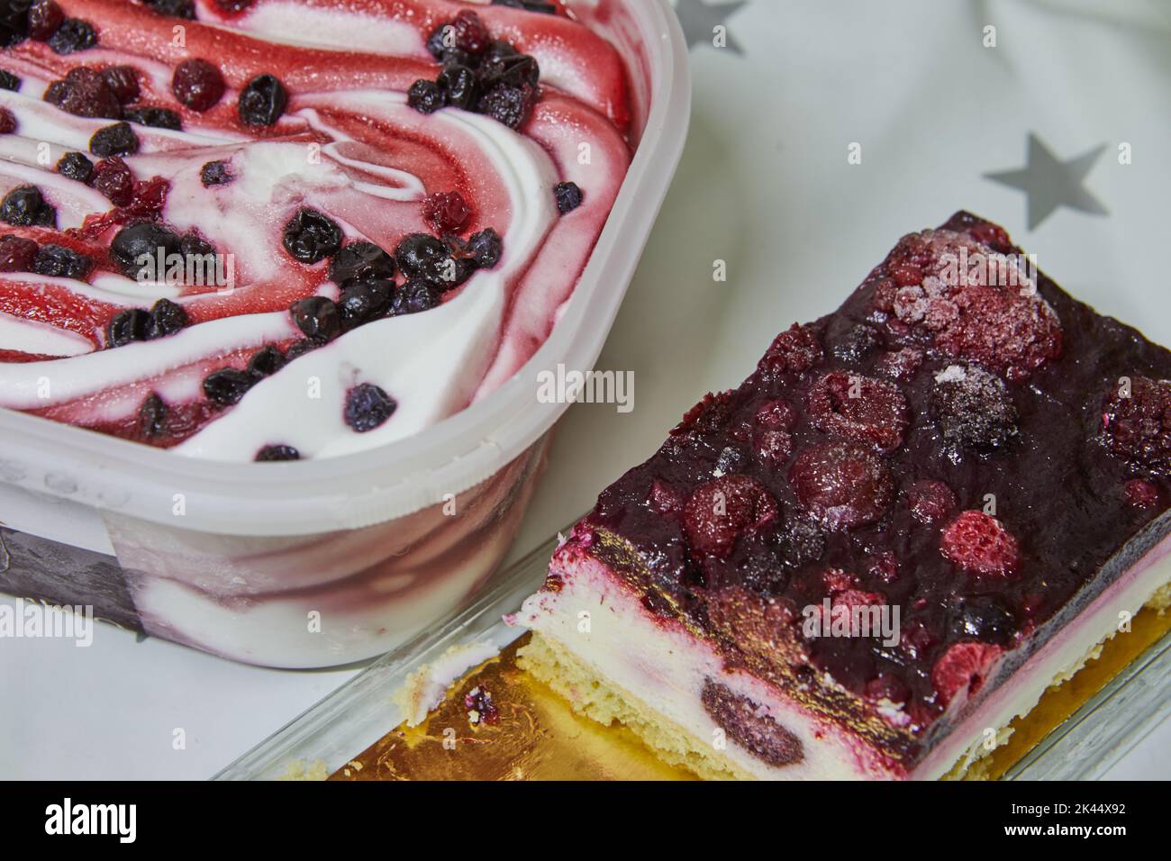 Gelato con mirtilli rossi e ciliegie in scatola e torta con bacche sul tavolo Foto Stock
