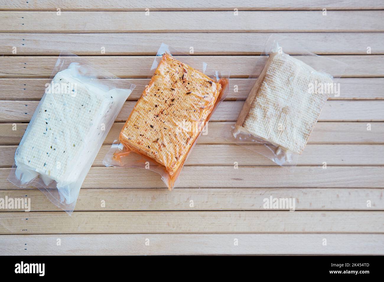 Vegan cibo a base di soia assortito, tofu cagliata di fagioli sul tavolo di legno. Prodotto naturale alternativo. Foto Stock