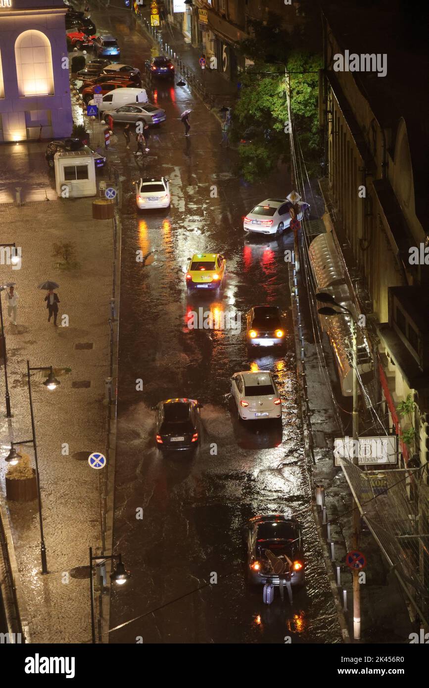 Vista notturna dall'alto su una strada allagata con auto durante la pioggia pesante, temporale Foto Stock