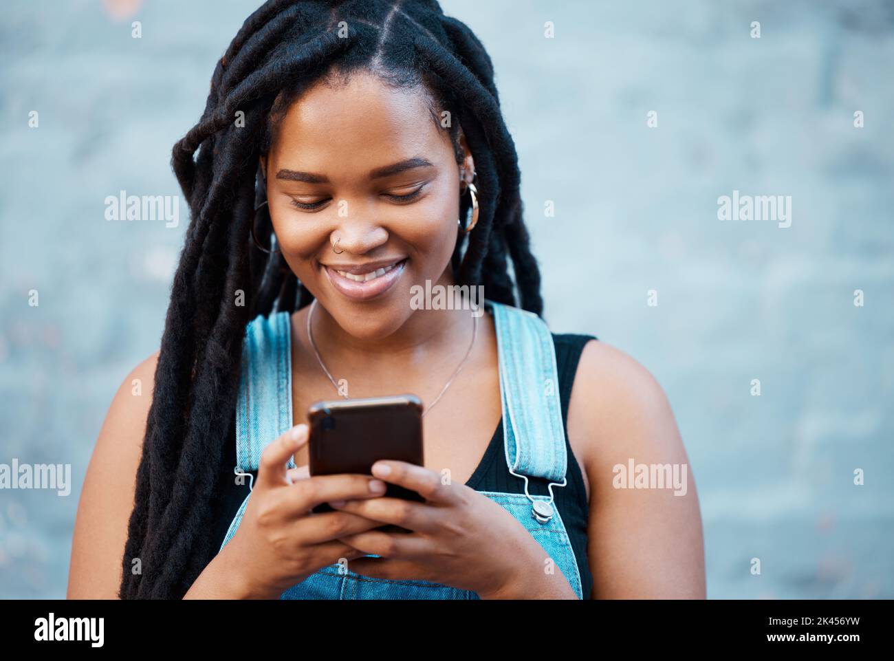 Donna nera, social media e telefono della città digitazione, contatto e comunicazione sulla tecnologia smartphone in Giamaica città. App mobili Gen z girl Foto Stock