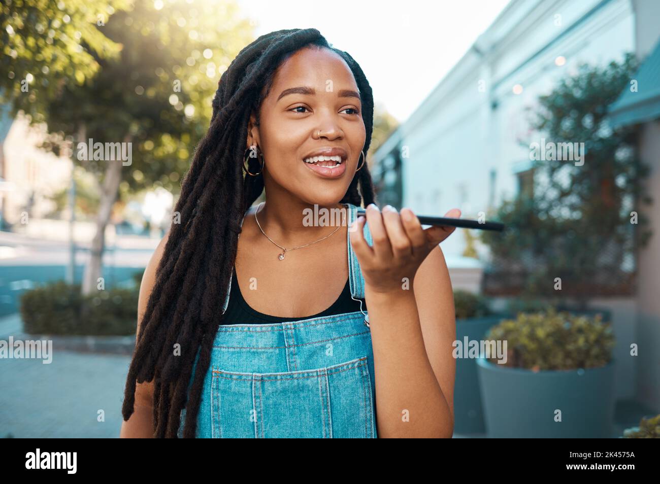 Donna nera, telefono con altoparlante e voce vocale sul microfono in Jamaica città strada all'aperto. Giovane ragazza urbana millenaria smartphone parlare, forte Foto Stock