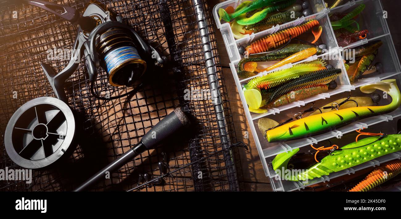 attrezzatura da pesca. canna, mulinello e lure box su sfondo di legno. banner Foto Stock