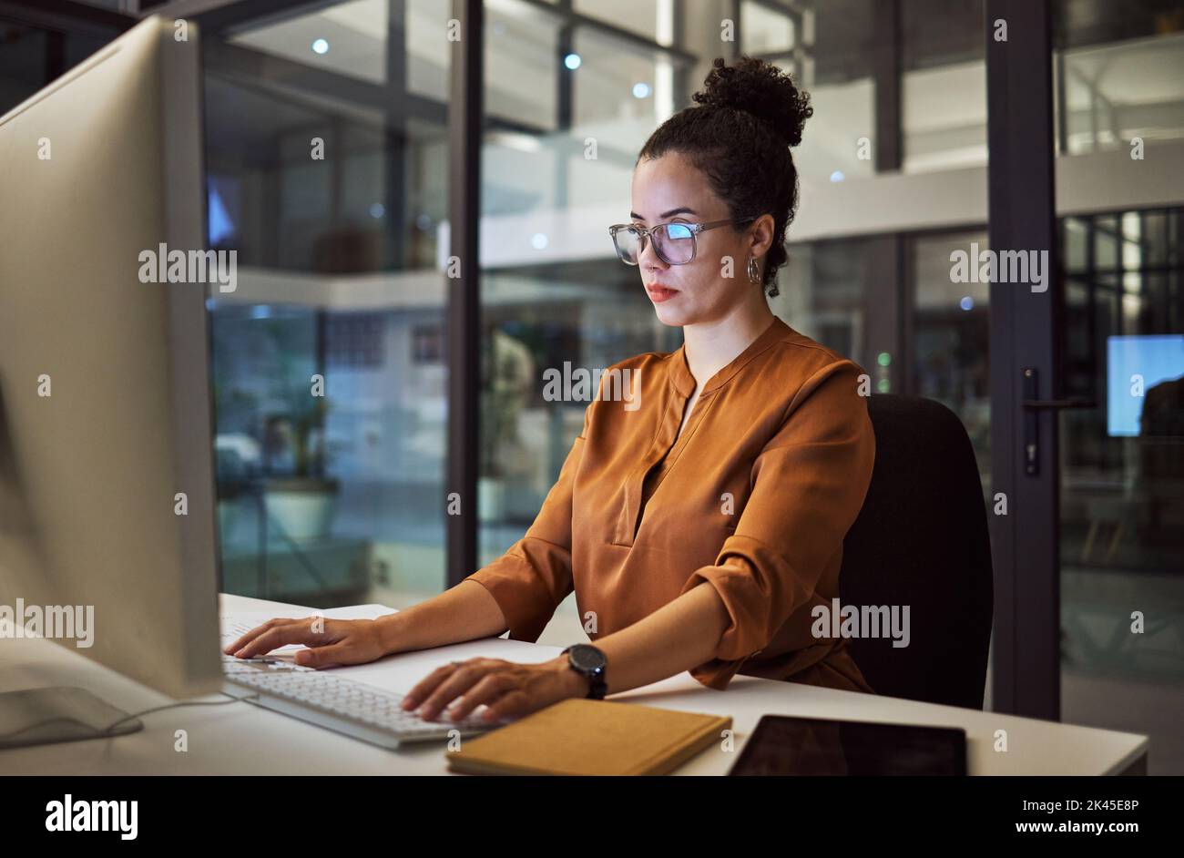 Computer, pensiero o donna d'affari in ufficio notturno di marketing digitale startup, agenzia pubblicitaria o creativa società messicana. Designer, lavoratore e. Foto Stock