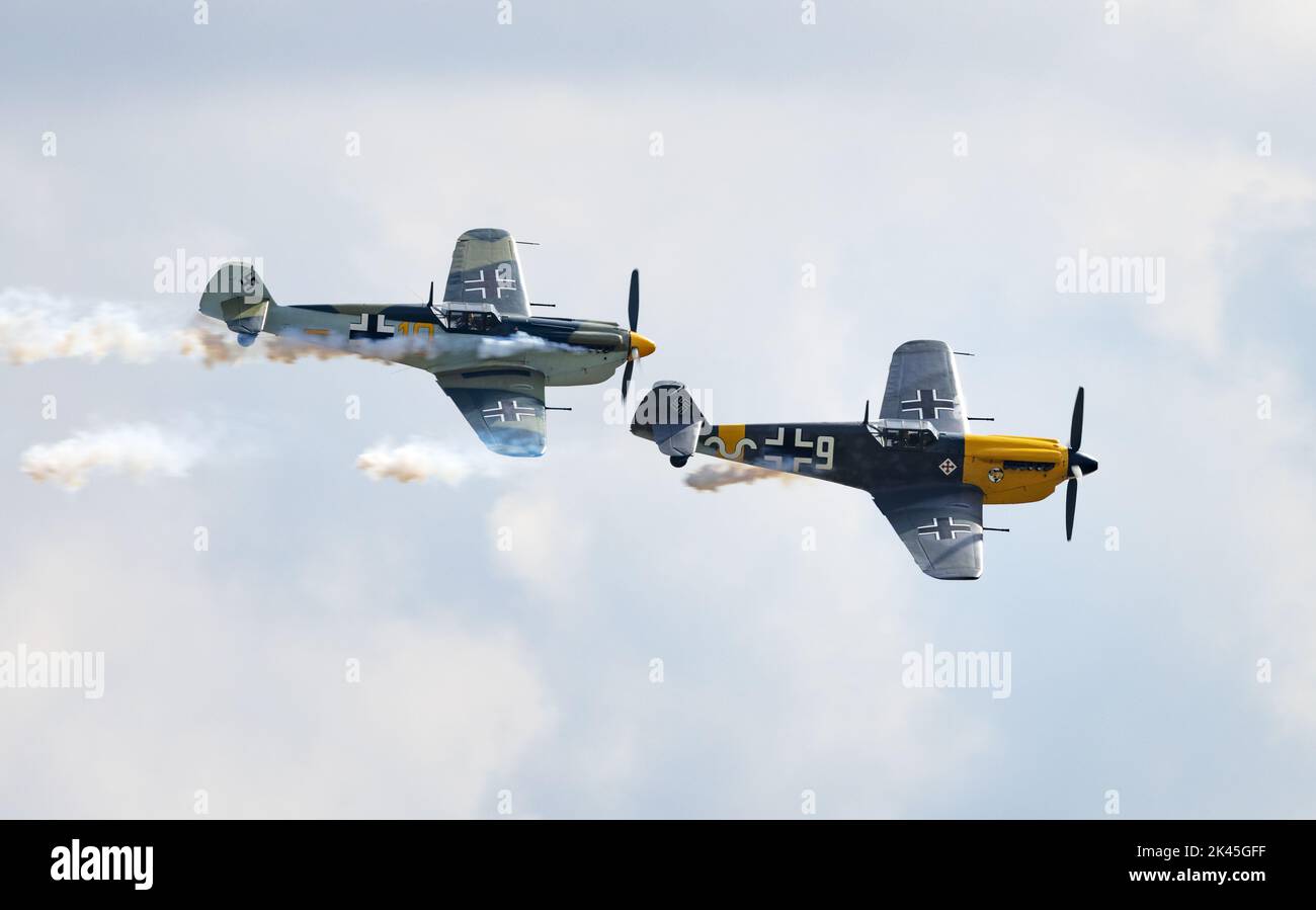 Due aerei Hispano ha-1112 Buchon - un aereo militare 1950s a colori tedeschi che vola al Duxford Airshow, Imperial War Museum, Duxford Cambridgeshire UK Foto Stock