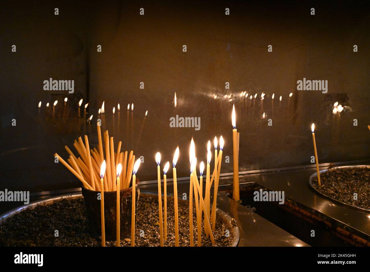 Candele lunghe e sottili che bruciano in una chiesa. Vista ravvicinata Foto  stock - Alamy
