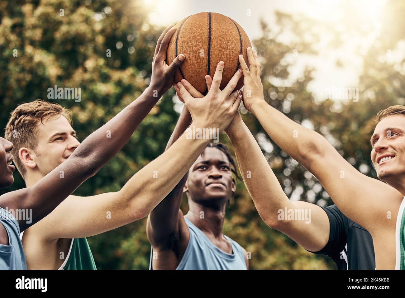 Formazione, amici e sostegno della comunità da parte dei giocatori di basket collegati a mano a sostegno di obiettivi sportivi e la visione. Fitness, fiducia e motivazione su Foto Stock